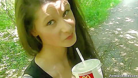 Brunette woman in red dress and blue shorts on the park